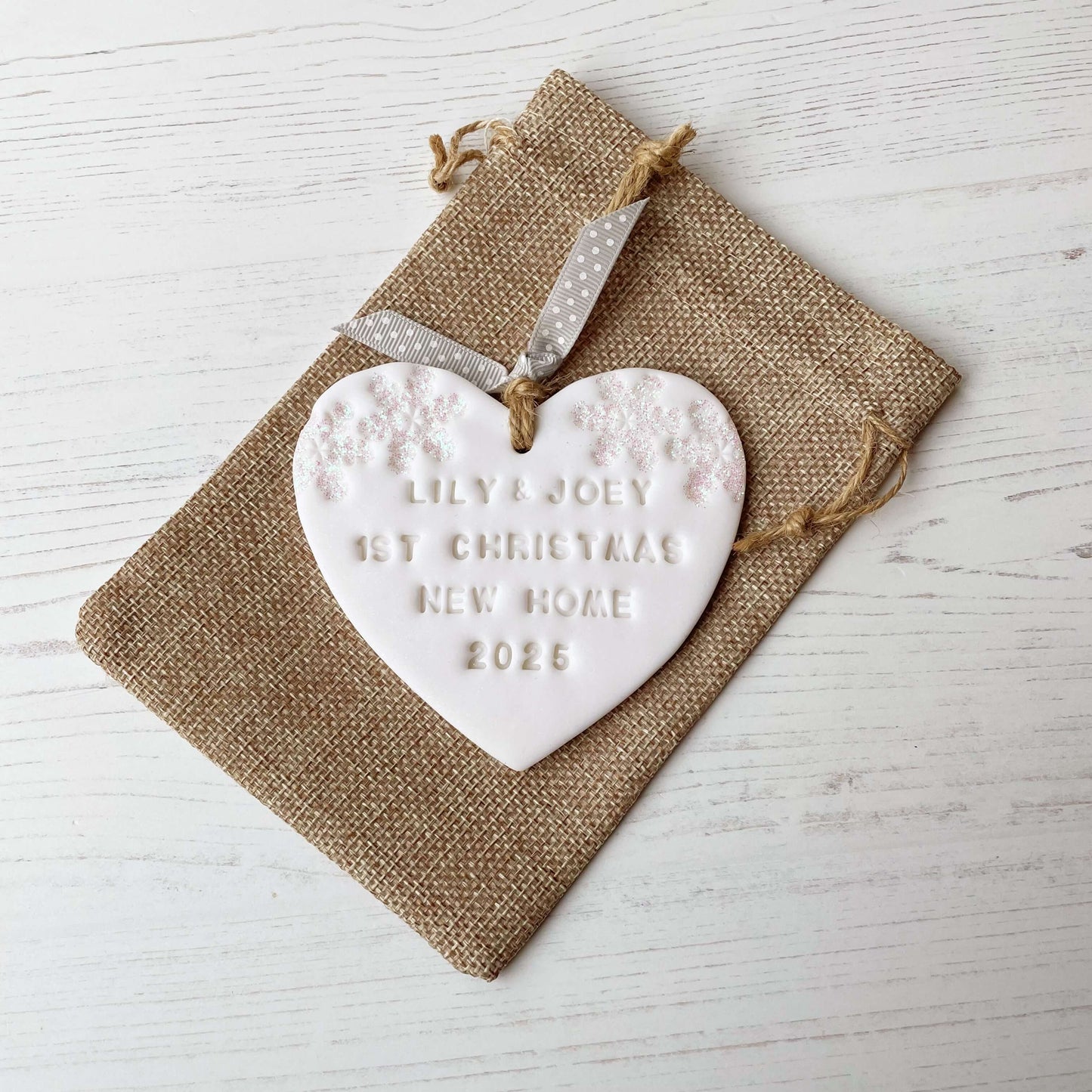 Personalised first Christmas new home heart ornament, glitter white clay with LILY & JOEY 1ST CHRISTMAS NEW HOME 2025 (text not painted), decorated with 2 iridescent glitter snowflakes on either side of the top of the heart