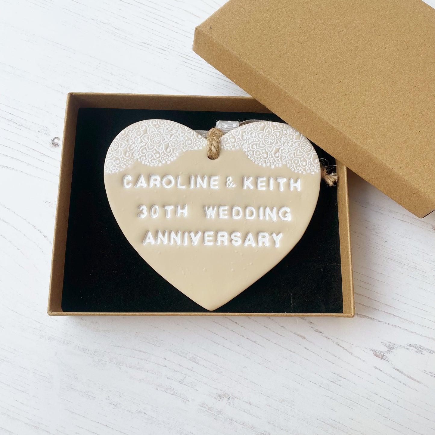 Personalised anniversary gift, beige clay heart with a white lace edge at the top of the heart with jute twine for hanging, the heart is personalised with CAROLINE & KEITH 30TH WEDDING ANNIVERSARY