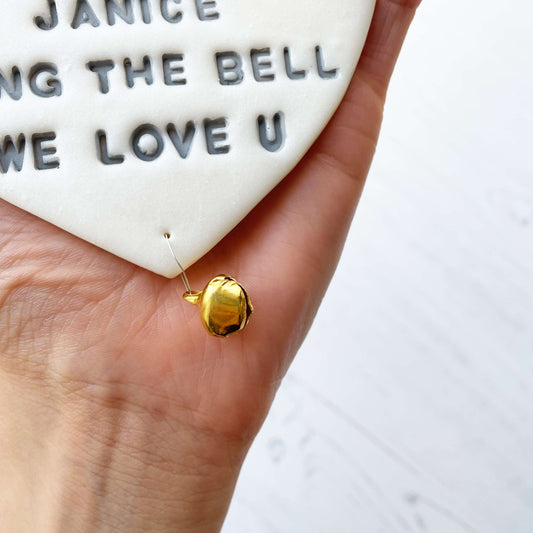 Personalised cancer survivor gift, pearlised white clay hanging heart with a grey lace edge at the top of the heart and a gold bell hanging below