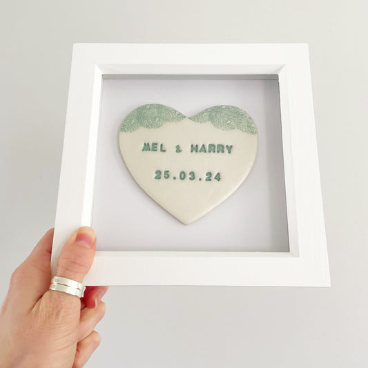 Personalised framed couples gift, pearlised white clay heart with a grey lace edge at the top of the heart in a white box frame, the heart is personalised with MEL & HARRY 25.03.24