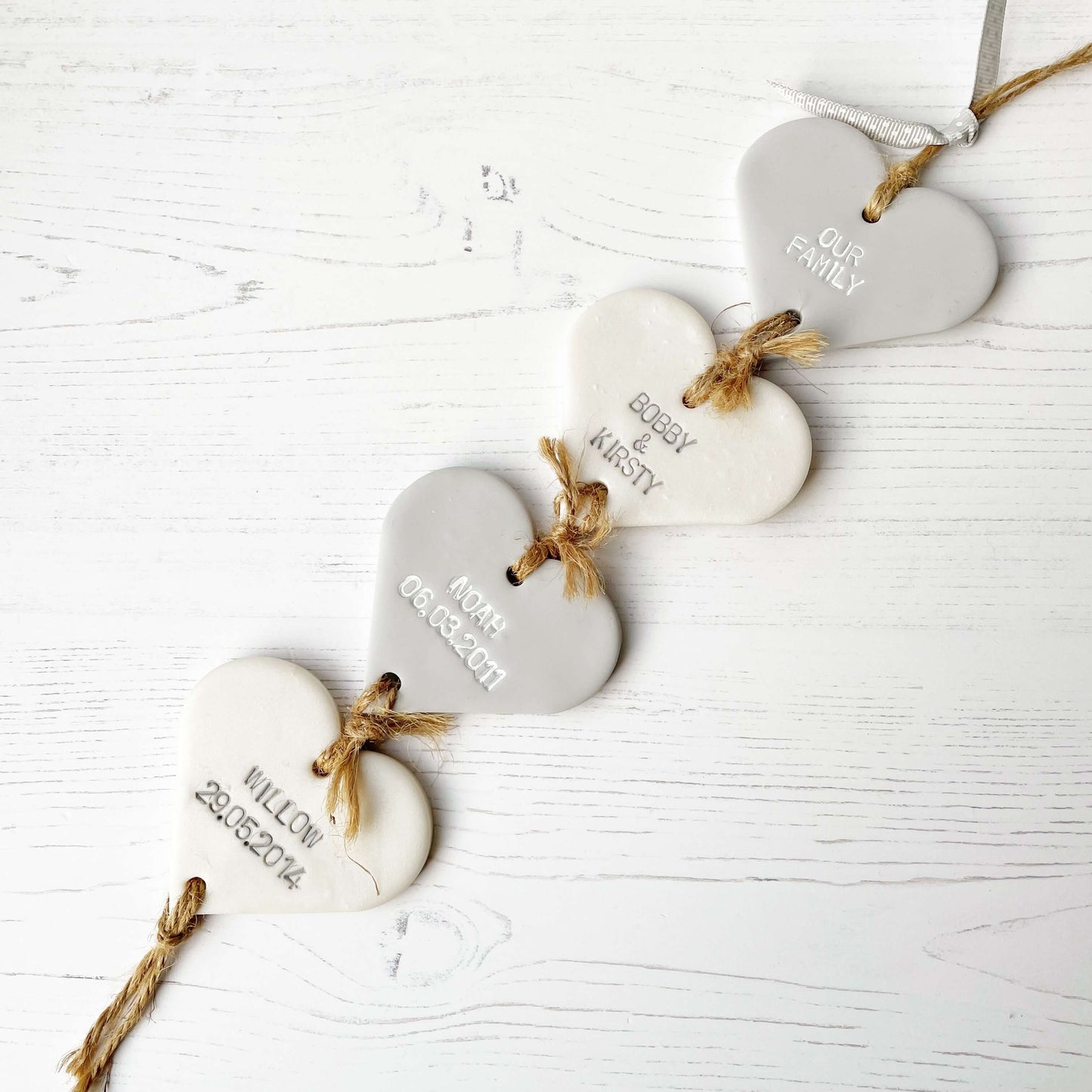 Family tree keepsake, grey small polymer clay heart with a pearlised white small heart hanging below, a small grey heart hanging below, a pearlised white heart hanging at the bottom, personalised with family names and dates