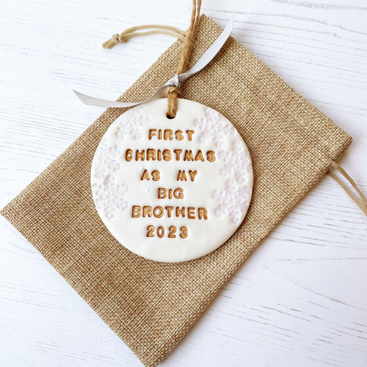 Personalised first Christmas as big brother bauble ornament, pearlised white clay round personalised with first Christmas as my big brother 2023 in gold paint, decorated with 3 iridescent glitter snowflakes on either side of the bauble