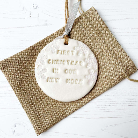 Personalised first Christmas in our new home bauble ornament, pearlised white round clay with FIRST CHRISTMAS IN OUR NEW HOME (text not painted), decorated with 3 iridescent glitter snowflakes on either side of the bauble