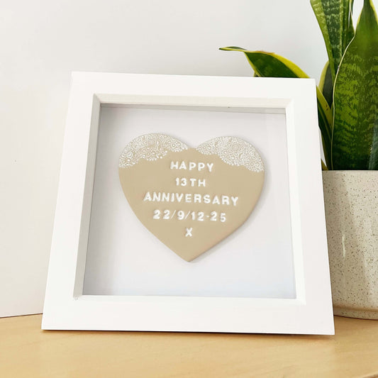 Personalised framed 13th wedding anniversary gift, beige clay heart with a white lace edge at the top of the heart in a white box frame, the heart is personalised with HAPPY 13TH ANNIVERSARY 22/9/12-25 X