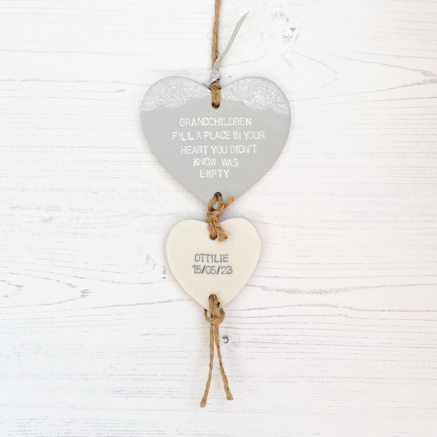 Grandparent keepsake with a large grey polymer clay heart with a quote “Grandchildren fill a place in your heart you didn’t know was empty” and a small pearlised white heart hanging below with a name and date of birth