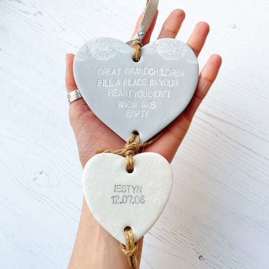 Great Grandparent keepsake with a large grey polymer clay heart with a quote “Great Grandchildren fill a place in your heart you didn’t know was empty” and a small pearlised white heart hanging below with a name and date of birth