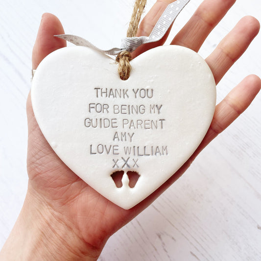 Personalised guide parents gift, pearlised white clay hanging heart with baby feet cut out of the bottom, the heart is personalised with THANK YOU FOR BEING MY GUIDE PARENTS AMY LOVE WILLIAM xXx