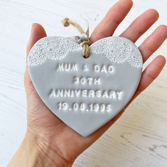 Personalised anniversary gift, grey clay heart with a white lace edge at the top of the heart with jute twine for hanging, the heart is personalised with MUM & DAD 30TH ANNIVERSARY 19.08.1995