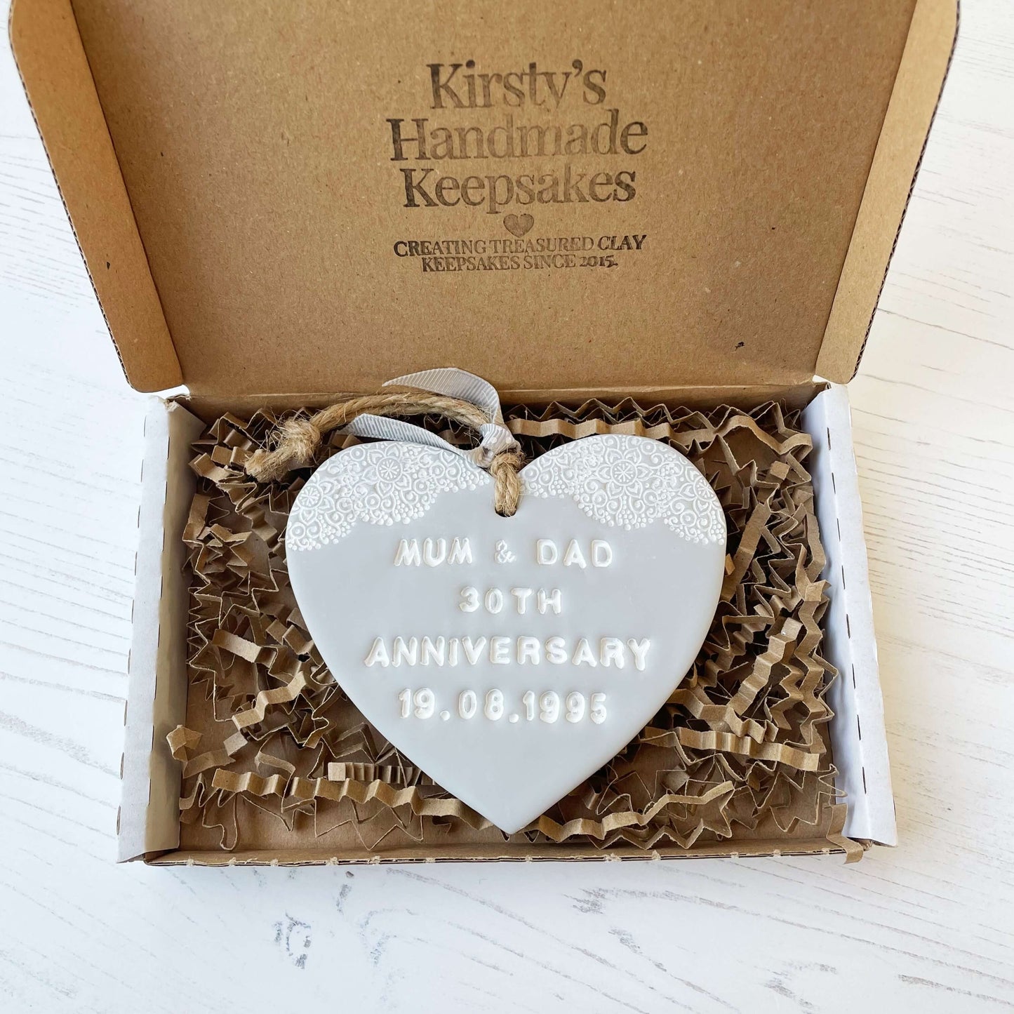 Personalised anniversary gift, grey clay heart with a white lace edge at the top of the heart with jute twine for hanging, the heart is personalised with MUM & DAD 30TH ANNIVERSARY 19.08.1995