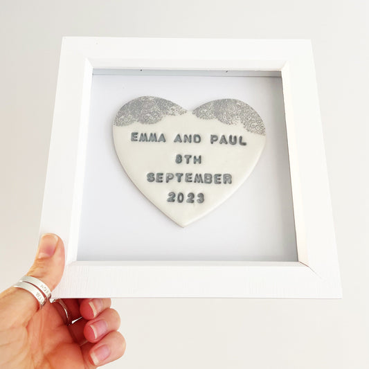 Personalised framed Valentine gift, pearlised white clay heart with a white lace edge at the top of the heart in a white box frame, the heart is personalised with EMMA AND PAUL 8TH SEPTEMBER 2023