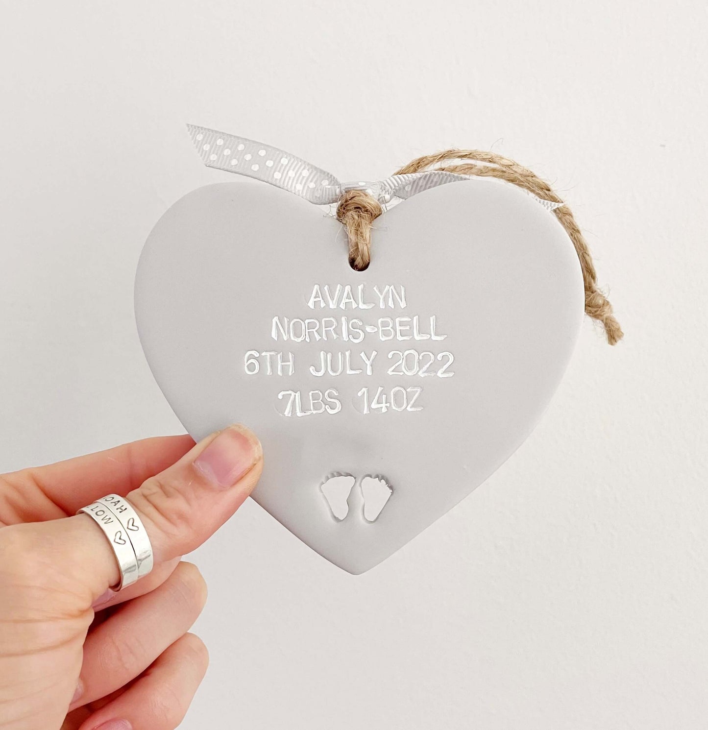 Personalised baby keepsake gift, grey clay hanging heart with baby feet cut out at the bottom of the heart, the heart is personalised with the baby’s name, date of birth, weight and time