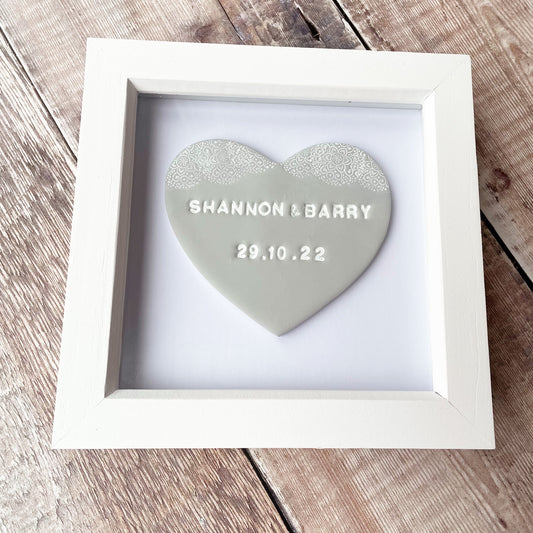 Personalised framed engagement gift, grey clay heart with a white lace edge at the top of the heart in a white box frame, the heart is personalised with SHANNON & BARRY 29.10.22