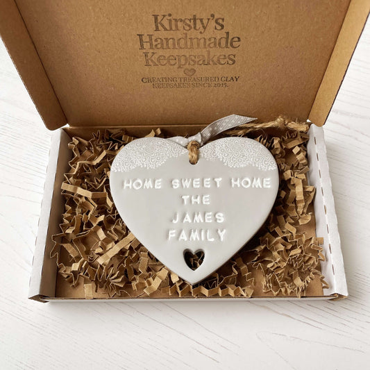 Personalised new home gift grey clay heart with a white lace edge at the top & a heart cut out at the bottom with twine for hanging personalised with HOME SWEET HOME THE JAMES FAMILY