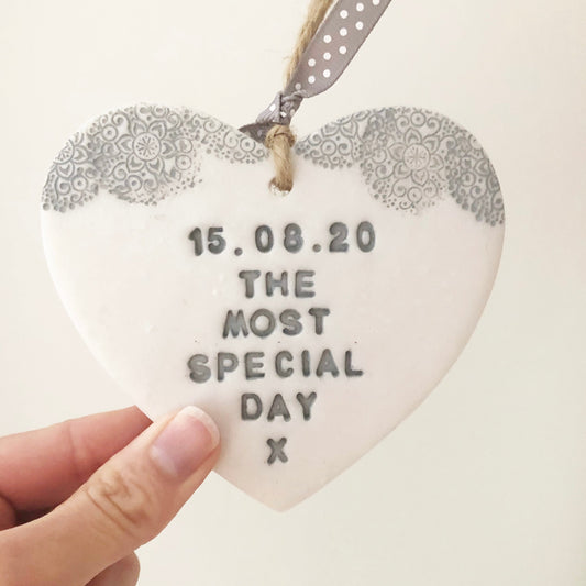 Personalised Valentine gift, pearlised white clay heart with a grey lace edge at the top of the heart with jute twine for hanging, the heart is personalised with 15.08.20 THE MOST SPECIAL DAY X