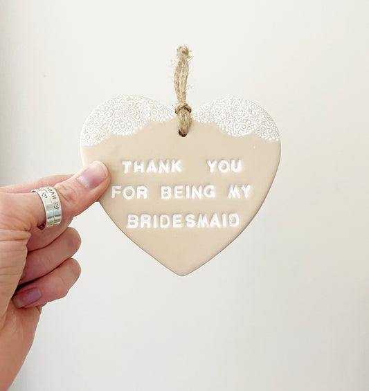 Personalised Bridesmaid thank you gift, beige clay hanging heart with a white lace edge at the top of the heart, the heart is personalised with THANK YOU FOR BEING MY BRIDESMAID