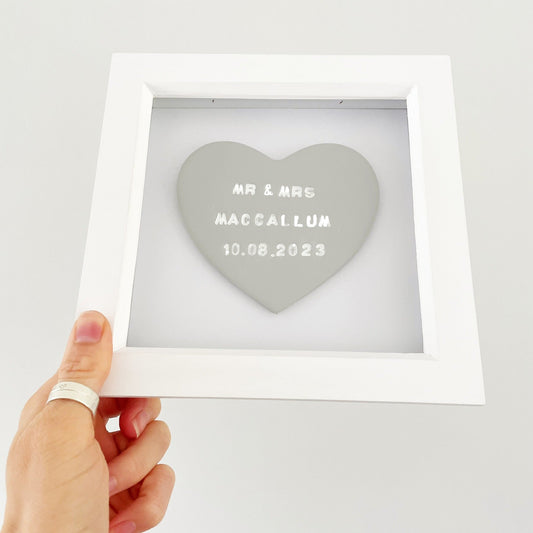 Personalised framed wedding heart gift, grey clay heart in a white box frame, with white personalisation with MR & MRS MACCALLUM 10.08.2023