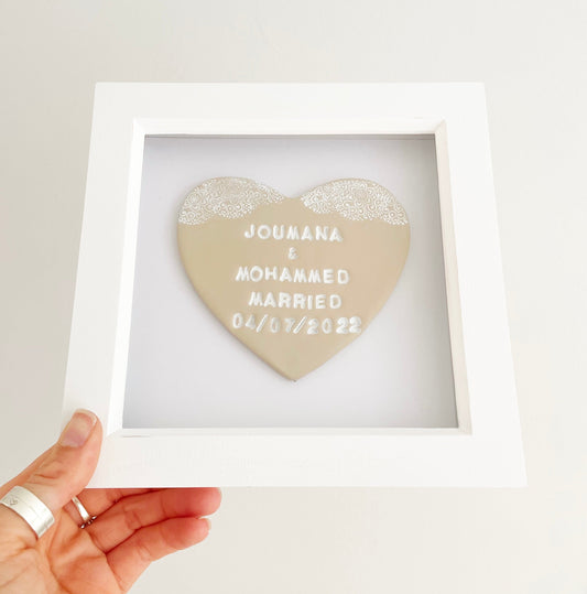 Personalised wedding gift, beige clay heart with a white lace edge at the top of the heart in a white box frame, the heart is personalised with JOUMANA & MOHAMMED MARRIED 04/07/2022