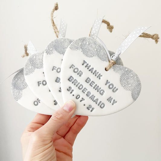 Personalised Bridesmaid thank you gift, 4 pearlised white clay hanging heart with a grey lace edge at the top of the heart, the heart is personalised with THANK YOU FOR BEING MY BRIDESMAID 31.07.21