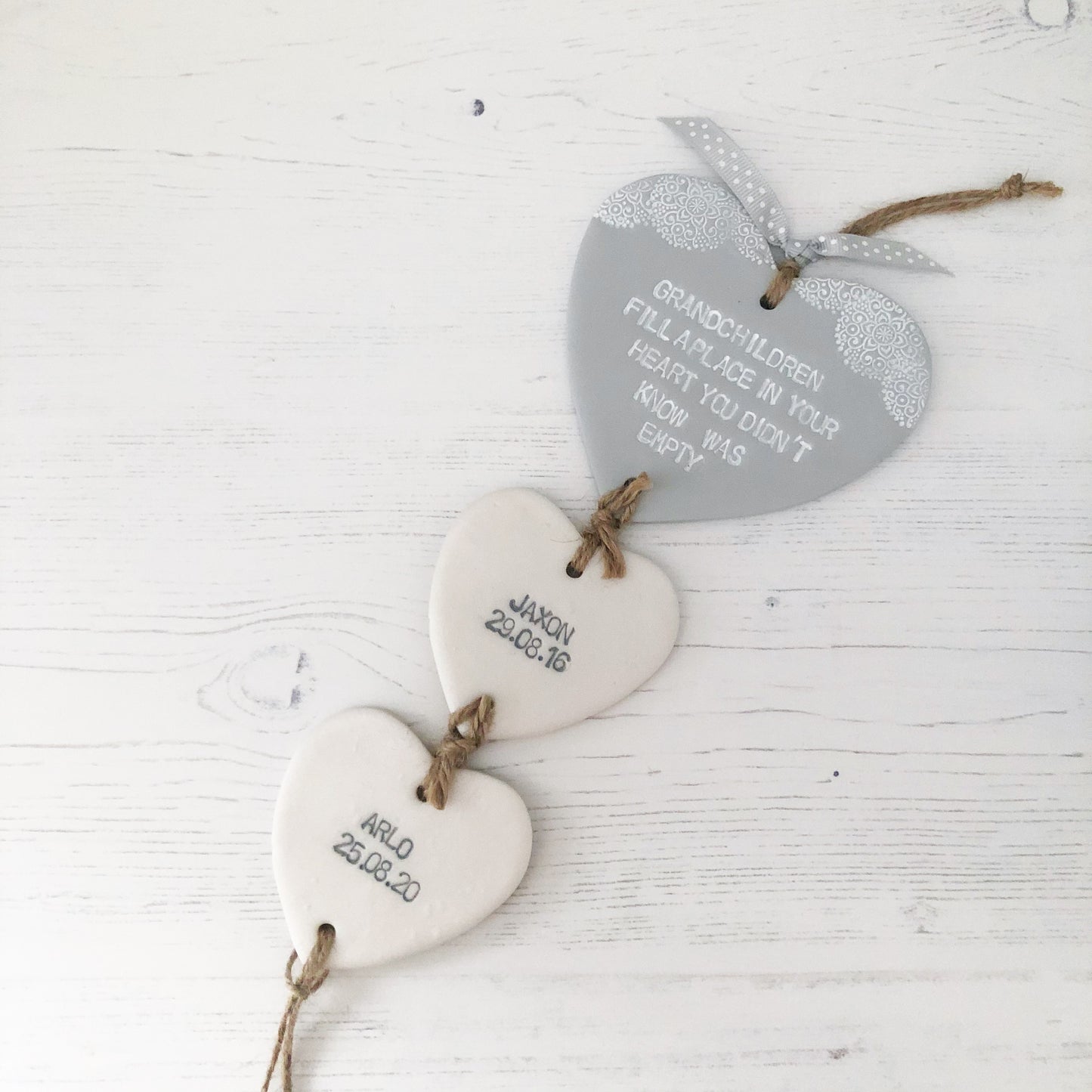 Grandparent keepsake with a large grey polymer clay heart with a quote on and 2 small pearlised white hearts hanging below with a names and dates of birth