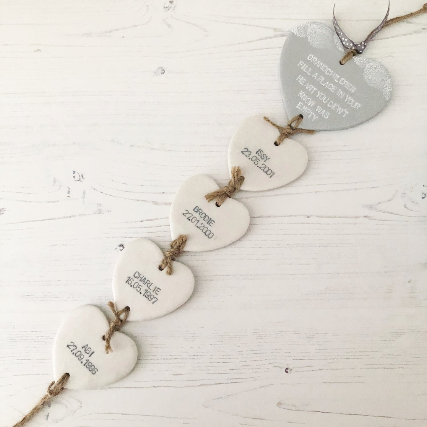 Grandparent keepsake with a large grey polymer clay heart with a quote on and 4 small pearlised white hearts hanging below with a names and dates of birth