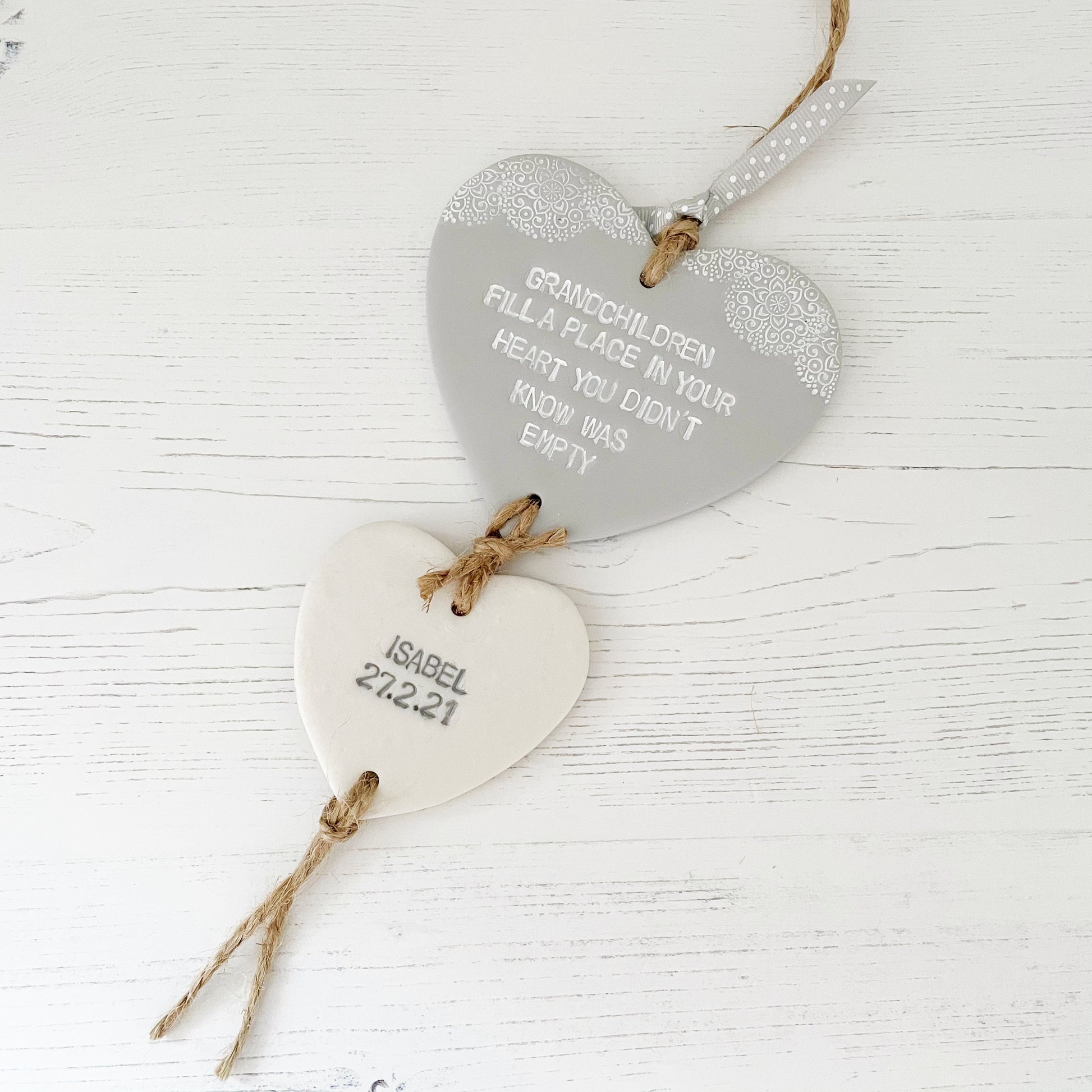 Grandparent keepsake with a large grey polymer clay heart with a quote “Grandchildren fill a place in your heart you didn’t know was empty” and a small pearlised white heart hanging below with a name and date of birth