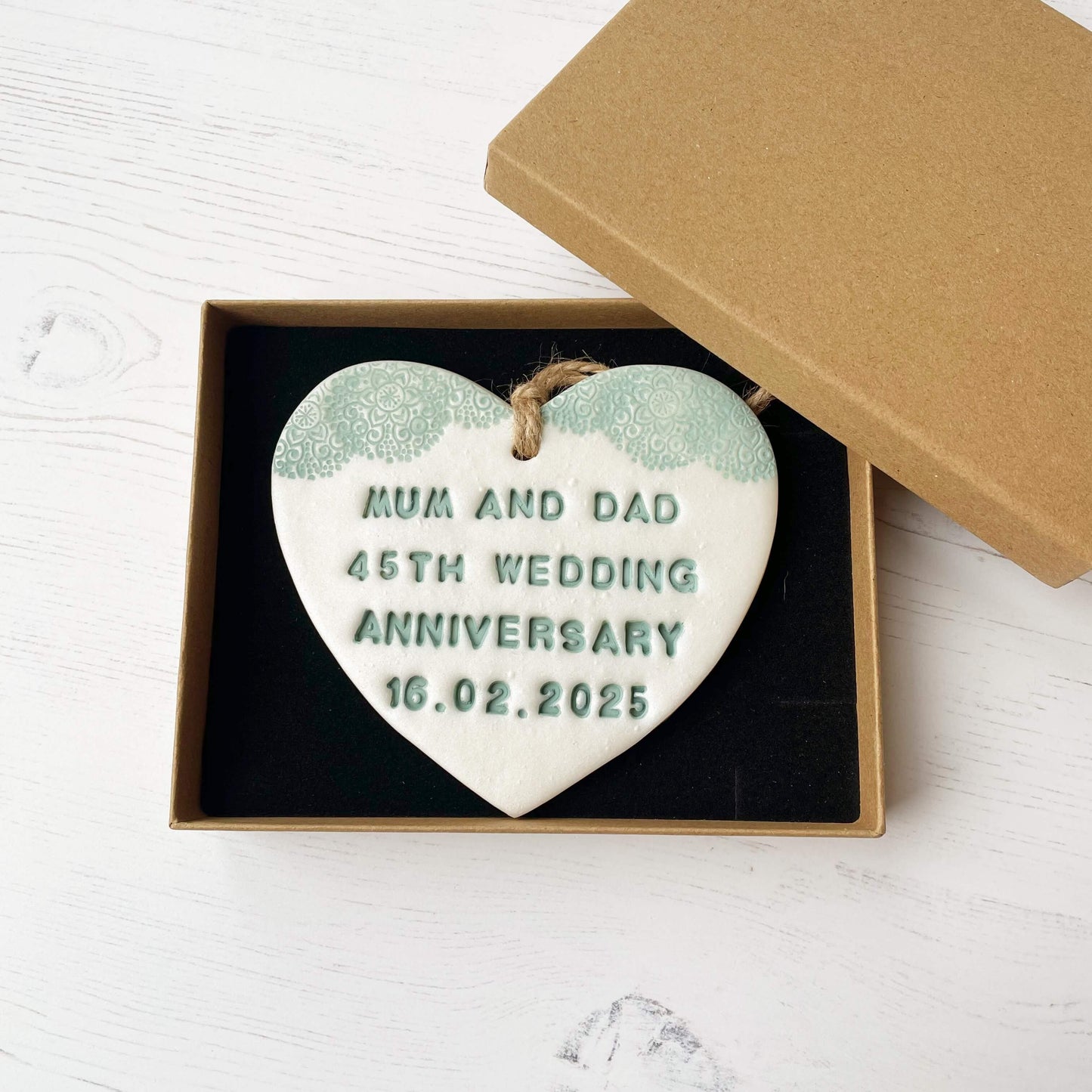 Personalised 45th anniversary gift, pearlised white clay hanging heart with a sage green lace edge at the top of the heart, the heart is personalised with MUM AND DAD 45TH WEDDING ANNIVERSARY 16.02.2025