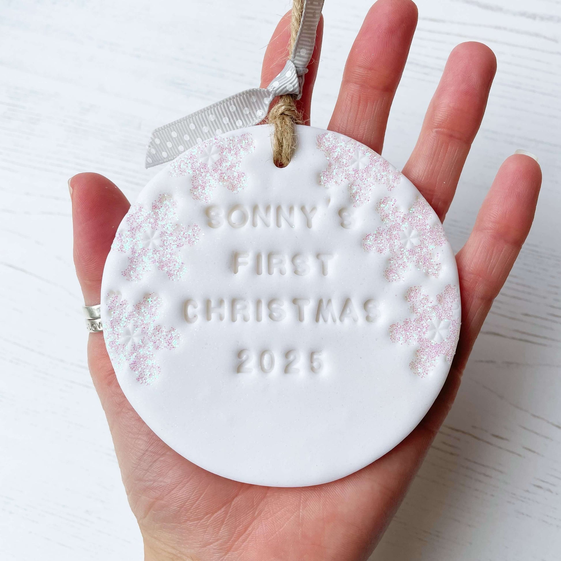 Personalised baby’s first Christmas bauble ornament, glitter white round clay with SONNY’S FIRST CHRISTMAS 2025 (letters not painted), decorated with 3 iridescent glitter snowflakes on either side of the bauble
