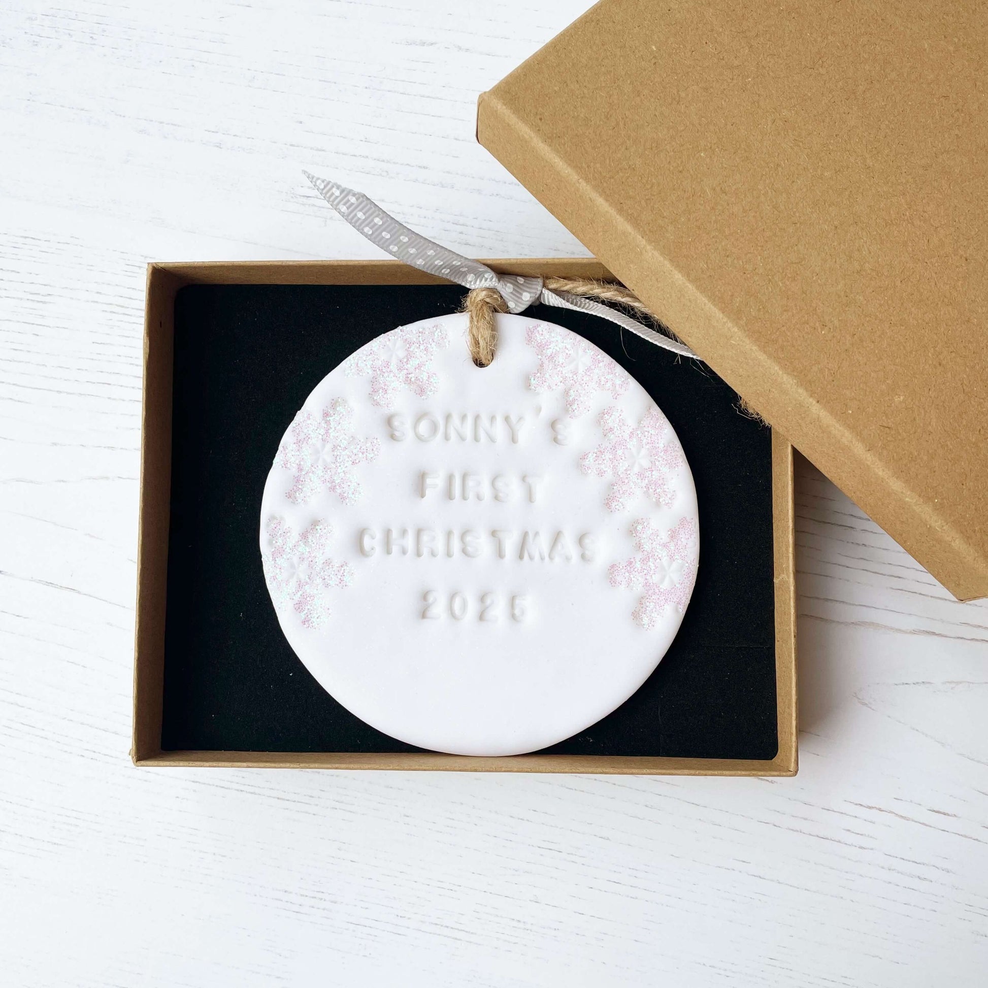Personalised baby’s first Christmas bauble ornament, glitter white round clay with SONNY’S FIRST CHRISTMAS 2025 (letters not painted), decorated with 3 iridescent glitter snowflakes on either side of the bauble