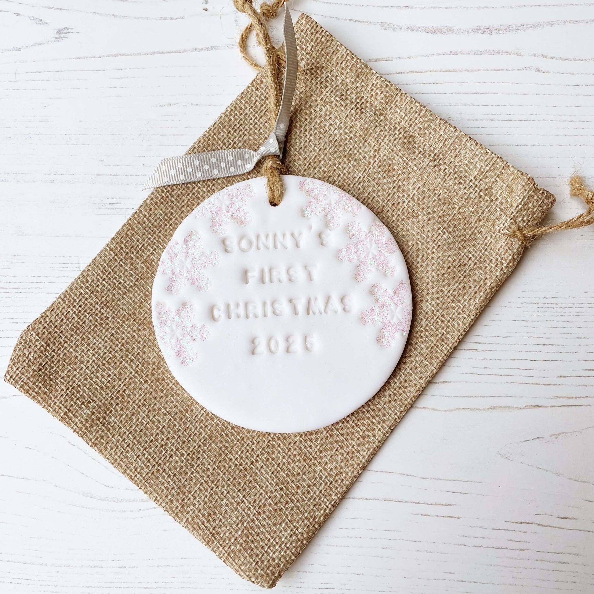 Personalised baby’s first Christmas bauble ornament, glitter white round clay with SONNY’S FIRST CHRISTMAS 2025 (letters not painted), decorated with 3 iridescent glitter snowflakes on either side of the bauble