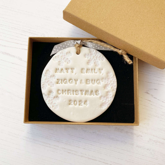 Personalised bump’s first Christmas bauble ornament, pearlised white round clay with MATT, EMILY, ZIGGY & BUG CHRISTMAS 2024, decorated with 3 iridescent glitter snowflakes on either side of the bauble