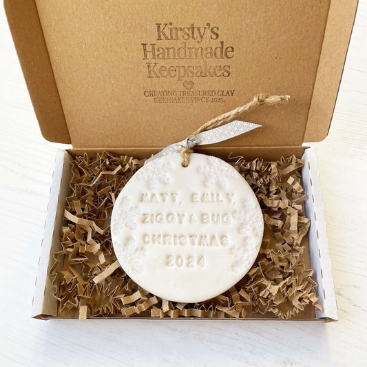 Personalised bump’s first Christmas bauble ornament, pearlised white round clay with MATT, EMILY, ZIGGY & BUG CHRISTMAS 2024, decorated with 3 iridescent glitter snowflakes on either side of the bauble