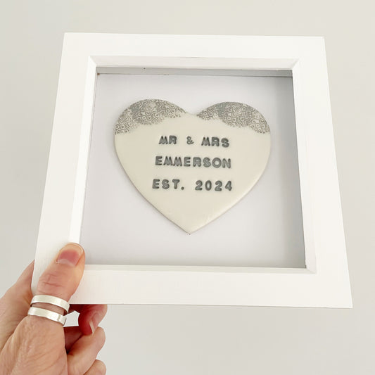 Personalised framed wedding heart gift, pearlised white clay heart with a grey lace edge at the top of the heart in a white box frame, the heart is personalised with MR & MRS EMMERSON EST. 2024