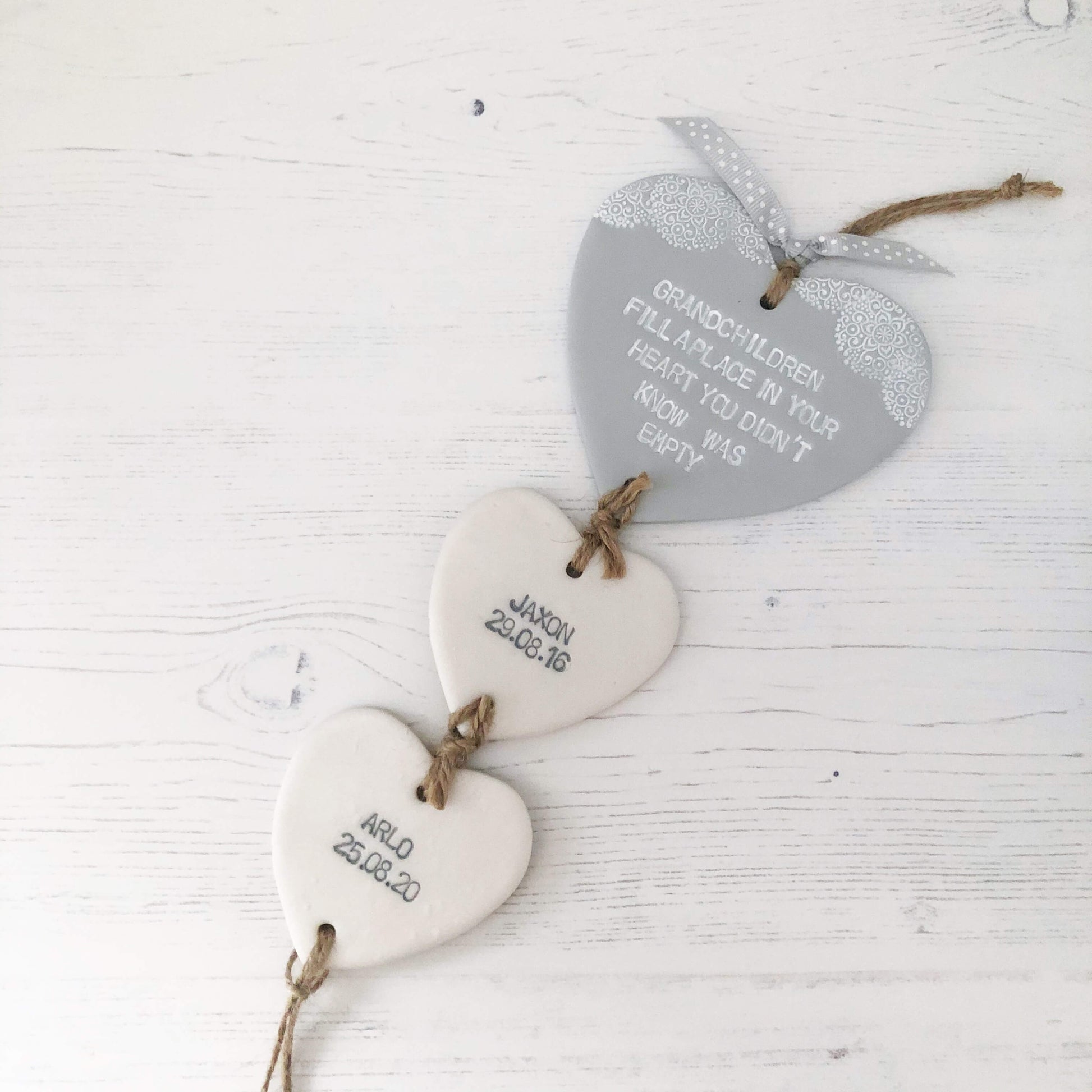 Grandparent keepsake with a large grey polymer clay heart with a quote on and 2 small pearlised white hearts hanging below with a names and dates of birth