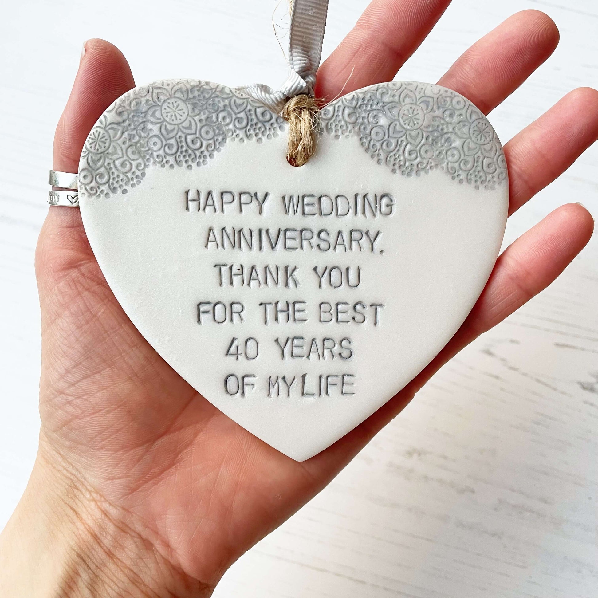 Personalised pearlised white clay hanging hearts with a grey lace edge at the top of the heart, the heart is personalised with HAPPY WEDDING ANNIVERSARY, THANK YOU FOR THE BEST 40 YEARS OF MY LIFE