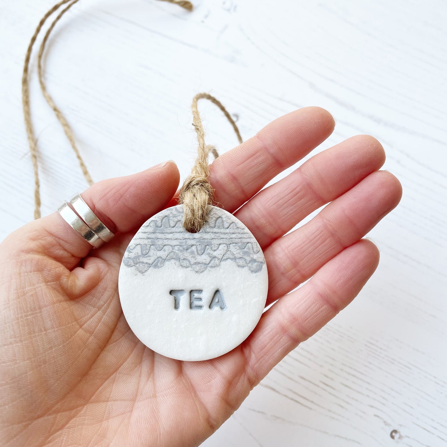 Round pearlised white clay kitchen canister label with tea stamped on each label in grey with a lace edge top