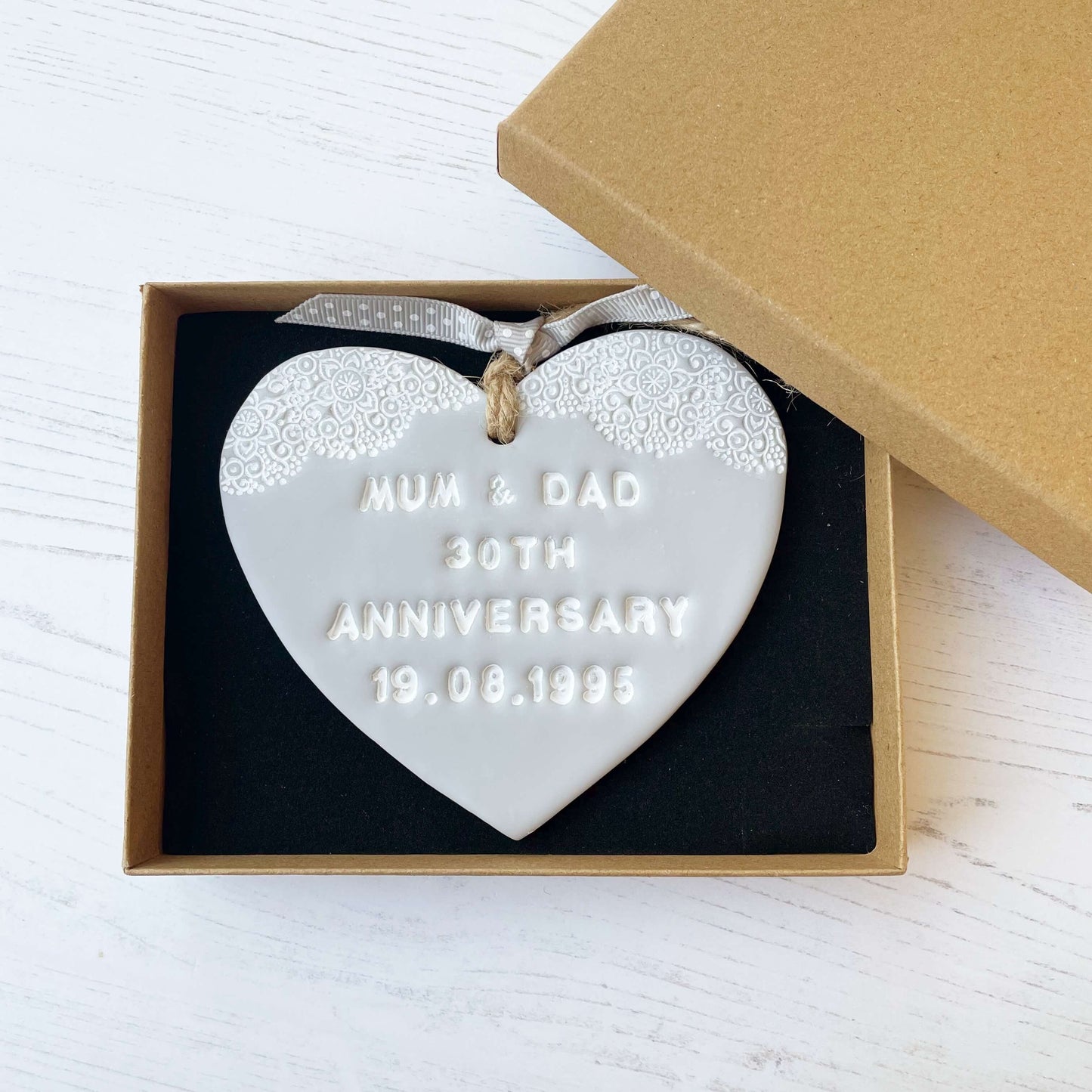 Personalised anniversary gift, grey clay heart with a white lace edge at the top of the heart with jute twine for hanging, the heart is personalised with MUM & DAD 30TH ANNIVERSARY 19.08.1995