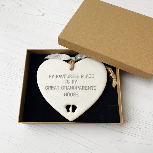 Pearlised white clay hanging heart with baby feet cut out of the bottom and grey personalisation, the heart is personalised with MY FAVOURITE PLACE IS MY GREAT GRANDPARENTS HOUSE.