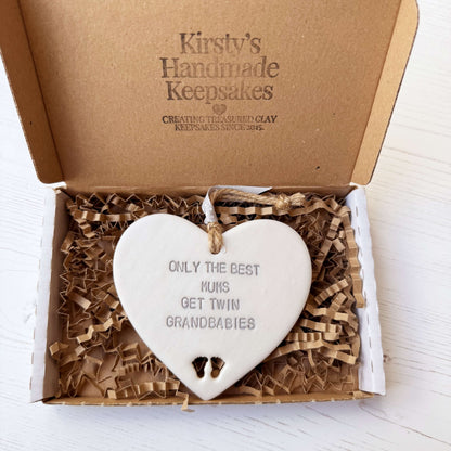 Pearlised white clay hanging heart with baby feet cut out of the bottom and grey personalisation, the heart is personalised with ONLY THE BEST MUMS GET TWIN GRANDBABIES