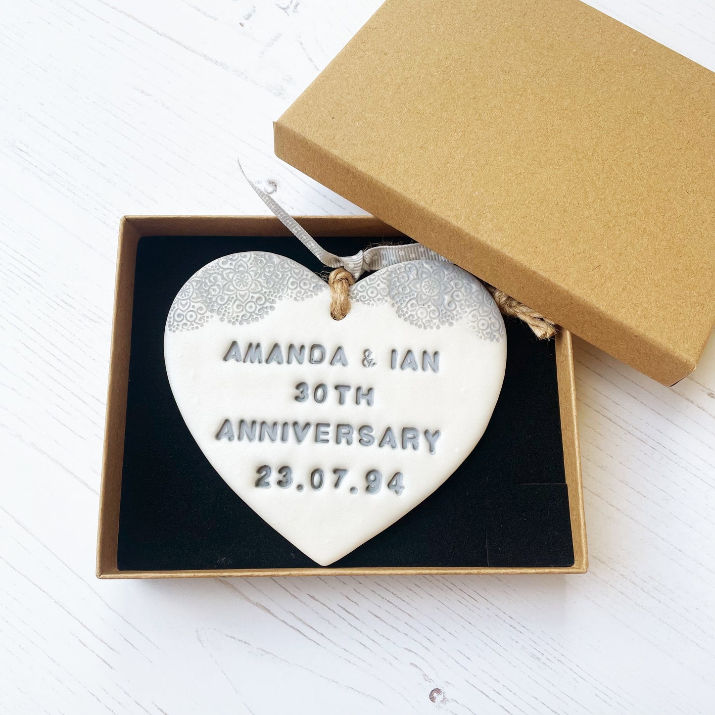 Personalised 30th Pearl anniversary gift, pearlised white clay hanging heart with a grey lace edge at the top of the heart, the heart is personalised with AMANDA & IAN 30TH ANNIVERSARY 23.07.94