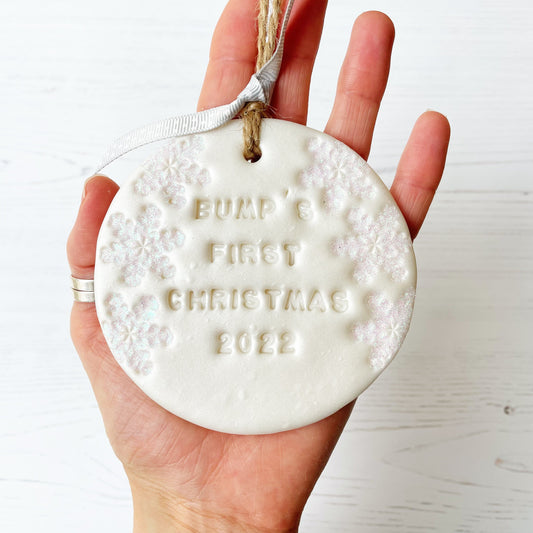 Personalised bump's first Christmas bauble ornament, pearlised white round clay with BUMP’S FIRST CHRISTMAS 2022 (text not painted), decorated with 3 iridescent glitter snowflakes on either side of the bauble