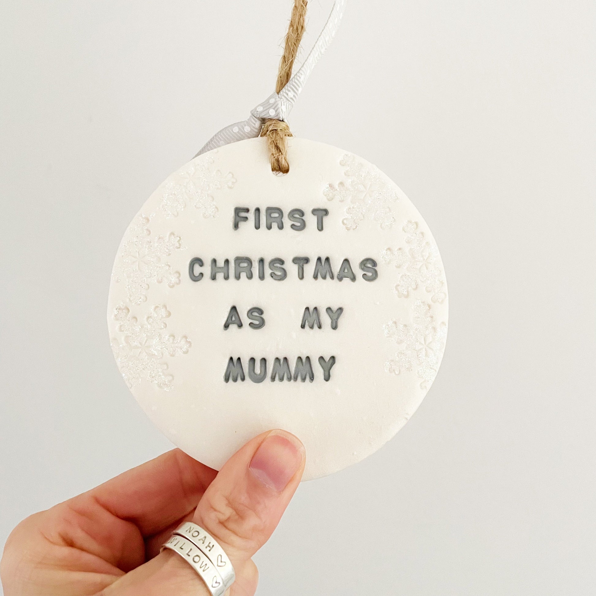 Personalised baby's first Christmas bauble ornament, pearlised white round clay with FIRST CHRISTMAS AS MY MUMMY in grey paint, decorated with 3 iridescent glitter snowflakes on either side of the bauble