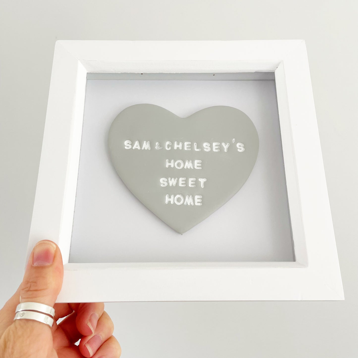 Personalised engagement gift, grey clay heart in a white box frame, the heart is personalised with SAM & CHELSEY'S HOME SWEET HOME