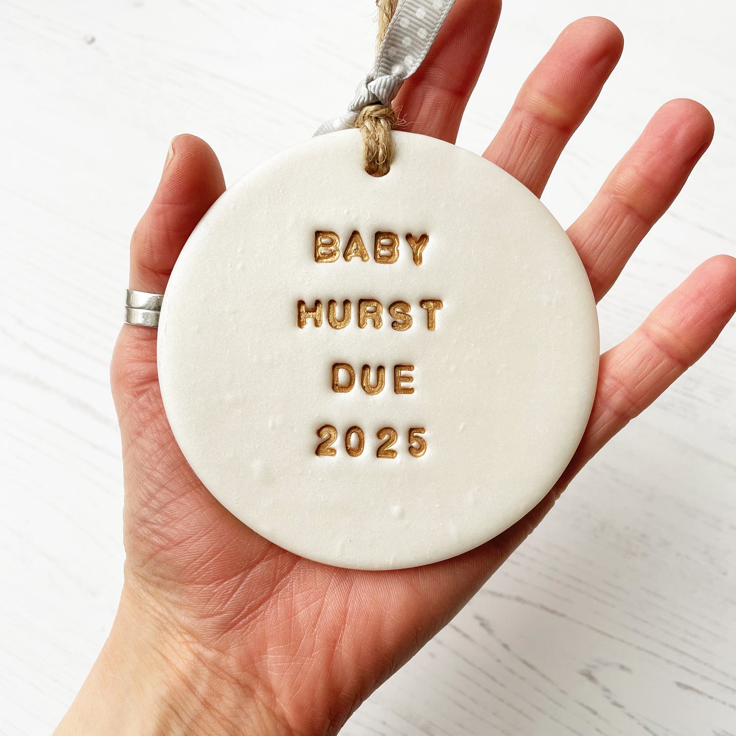 Personalised pregnancy reveal Christmas bauble ornament, pearlised white round clay with BABY HURST DUE 2025 in gold paint