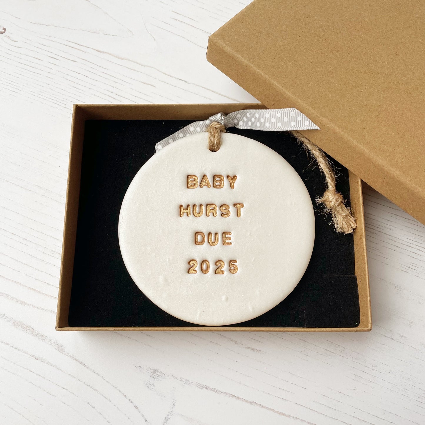 Personalised pregnancy reveal Christmas bauble ornament, pearlised white round clay with BABY HURST DUE 2025 in gold paint