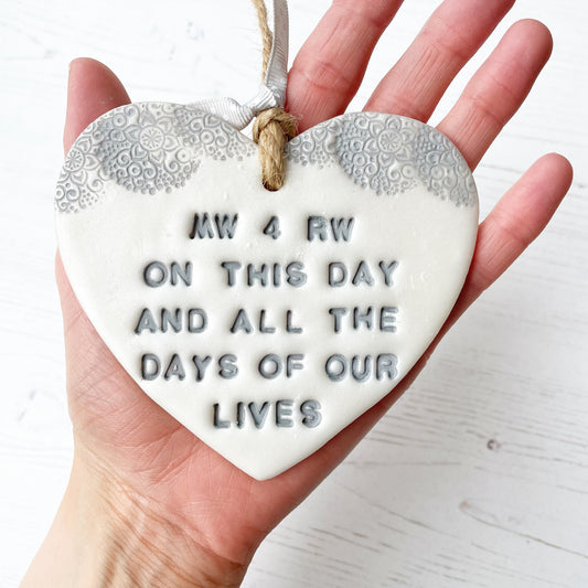 Personalised anniversary gift, pearlised white clay hanging heart with a grey lace edge at the top of the heart, the heart is personalised with MW & RW ON THIS DAY AND ALL OF THE DAYS OF OUR LIVES