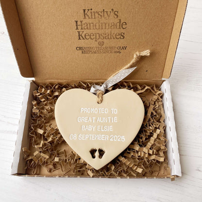 Beige clay hanging heart with baby feet cut out of the bottom and white personalisation, the heart is personalised with PROMOTED TO GREAT AUNTIE BABY ELSIE 08 SEPTEMBER 2025