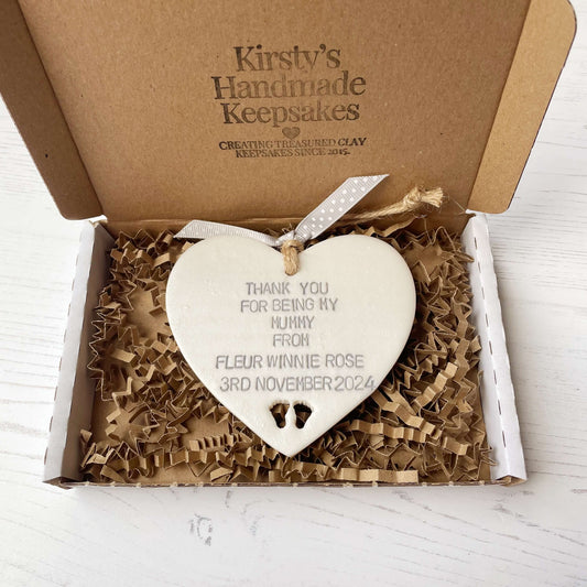 Personalised Mother’s Day gift, pearlised white clay hanging heart with baby feet cut out at the bottom of the heart, the heart is personalised with THANK YOU FOR BEING MY MUMMY FROM FLEUR WINNIE ROSE 3RD NOVEMBER 2024