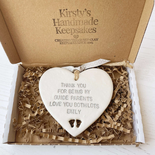 Personalised guide parents gift, pearlised white clay hanging heart with baby feet cut out of the bottom, the heart is personalised with THANK YOU FOR BEING MY GUIDE PARENTS LOVE YOU BITH LOTS EMILY